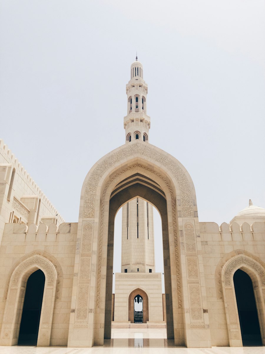 A tall minaret seen through a carved stone archway
